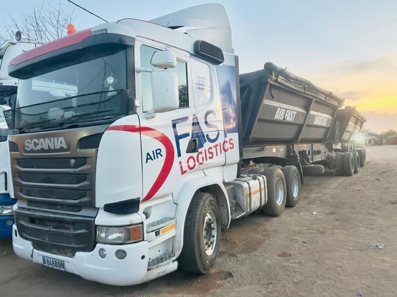 Scania truck with side-tipper trailer at sunset