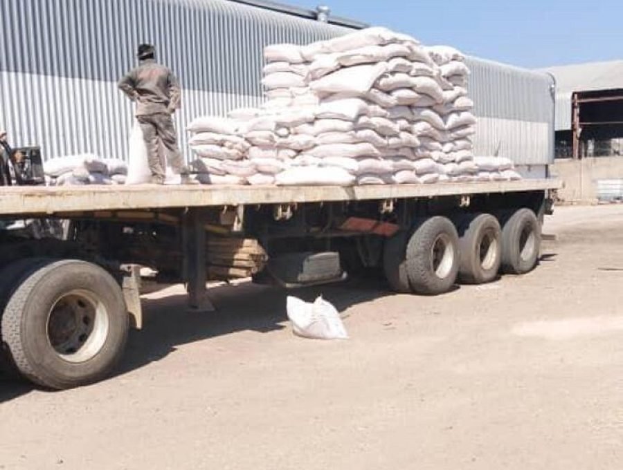 Flat-deck trailer loaded with bagged agricultural cargo